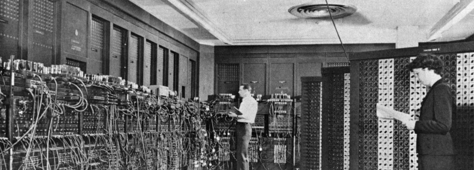 The ENIAC, an early room-sized electronic computer, with operators at its panels.